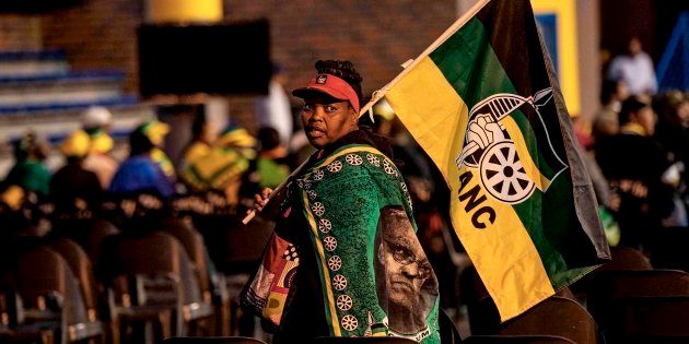 An African National Congress supporter walks with the party's flag as South African Deputy President and ruling party African National Congress (ANC) presidential candidate Cyril Ramaphosa gives a public lecture at the Orlando Communal Hall on November 13, 2017 in Johannesburg, South Africa.