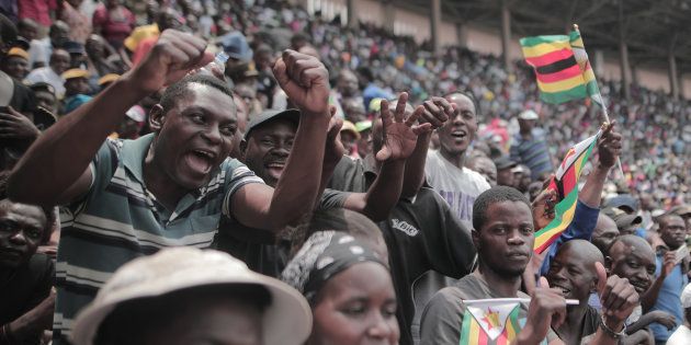 People react as Zimbabwean new President Emmerson Mnangagwa is officially sworn-in during a ceremony in Harare on November 24, 2017.