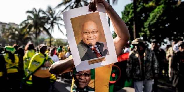 A supporter wearing the colours of the ANC and holding a portrait of former South African president Jacob Zuma takes part in a rally in support of Zuma on June 8, 2018 outside the High Court, in Durban.