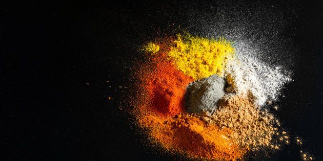 Spilled powder spices on black background - Abstract