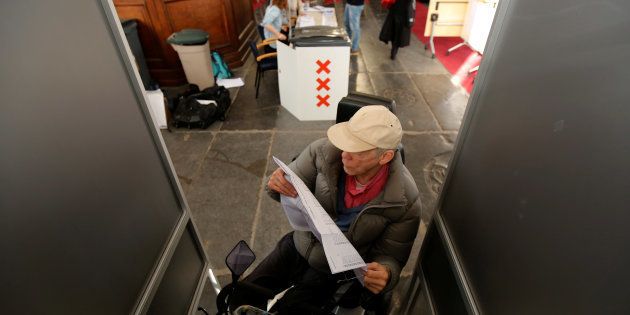 A voter studies a list of candidates for the general election in Amsterdam.