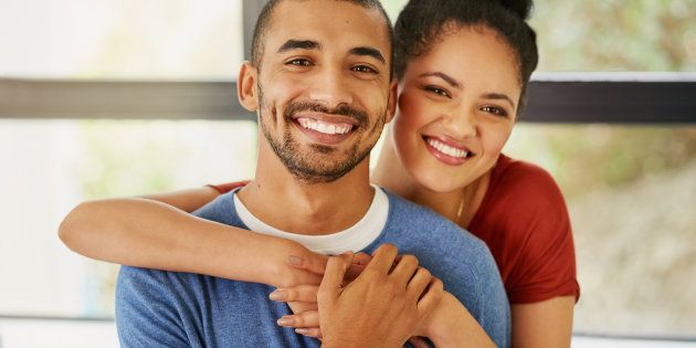 Portrait of a happy young couple embracing at home