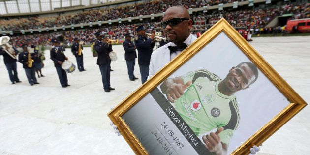 A man holds a framed picture of South African national soccer team goalkeeper and captain, Senzo Meyiwa during his funeral service in Durban on November 1, 2014.