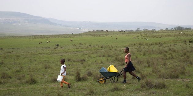 South African children in Kwa-Zulu Natal walk to the last tap with running water after other communal taps were cut off due to drought.