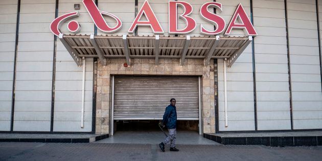 A security official stands at the shuttered entrance to the closed Absa Bank headquarters in Johannesburg on June 28, 2017, as unseen members of the Black First Land First movement (BLF) demonstrate.