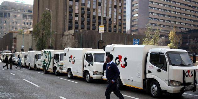A cash-in-transit worker walks past armoured vehicles parked on the street in Johannesburg during a nationwide protest on June 12 2018, following a spate of deadly heists this year.