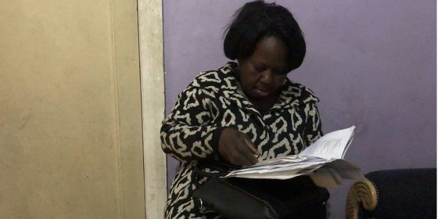 Kundji Tembo goes through her hospital and home affairs documents in a room she is sharing with her daughter and two other family members.