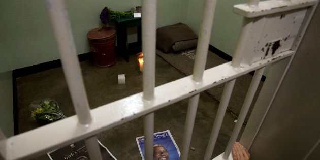 A lit candle in former South African president Nelson Mandela's cell on Robben Island, as part of a night vigil in December 2013 to honour Mandela.