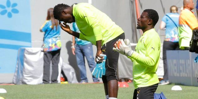 Ghana’s goalkeepers, Stephen Adams (L) and Fatawu Dauda (R), pray before a Fifa World Cup 2014 match.
