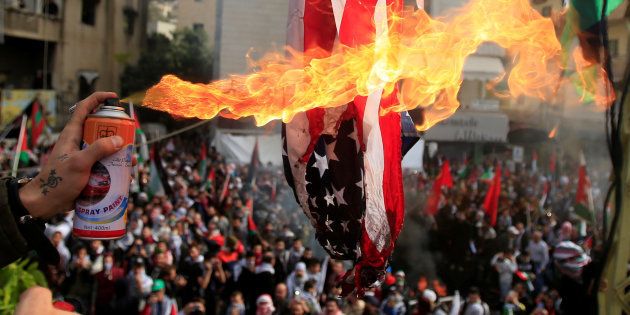 Protesters set a U.S flag on fire near the U.S. embassy in Awkar north of Beirut, Lebanon December 10,2017.