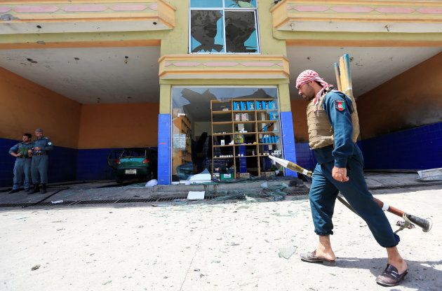 An Afghan policeman inspects the site of a suicide attack in Jalalabad city, Afghanistan July 10, 2018. REUTERS/Parwiz