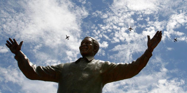 South African military jet fighters fly past a 9-metre (30-feet) bronze statue of the late former South African President Nelson Mandela after it was unveiled as part of the Day of Reconciliation Celebrations at the Union Buildings in Pretoria December 16, 2013.