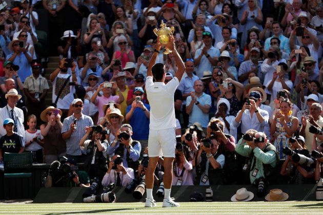 Tennis - Wimbledon - All England Lawn Tennis and Croquet Club, London, Britain - July 15, 2018 Serbia's Novak Djokovic celebrates with the trophy after winning the men's singles final against South Africa's Kevin Anderson REUTERS/Andrew Boyers