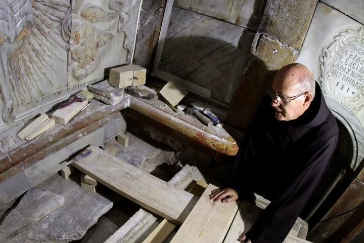 A Franciscan friar looks at the exposed the Tomb of Jesus, where his body is believed to have been laid, as part of conservation work done by a team of Greek team of preservation experts in Jerusalem on late on October 28, 2016.