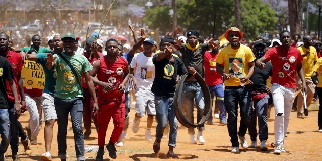 Demonstrators gesture at a photographer during a protest over planned increases in tuition fees outside the Union building in Pretoria, South Africa October 23, 2015. South African police fired stun grenades at students who lit fires outside President Jacob Zuma's offices following a week of protests, the first signs of the post-apartheid 'Born Free' generation flexing its muscle. REUTERS/Siphiwe Sibeko?