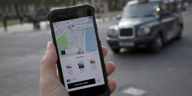 A photo illustration shows the Uber app on a mobile telephone, as it is held up for a posed photograph, with a London Taxi in the background, in London, Britain November 10, 2017.