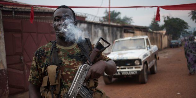 An armed militiaman, stands guard at the entrance of the headquarters of the Muslim 'self-defence force' group of the PK5 majority Muslim district of Bangui, on November 15, 2017.