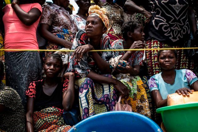 A Congolese woman looks on while people wait for their ration of food to be handed out at a food distribution on October 25, 2017 in Kasala, in the restive region of Kasai, central Democratic Republic of Congo. Conflict in the Kasai Provinces between the local militia, Kamwina Nsapu and Government troops have displaced 1.4 million people since August, 2016. As three crop cycles have been missed and displacement continues, sever malnutrition is becoming a present issue.