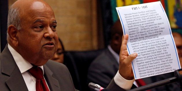 Former finance minister Pravin Gordhan holds a copy of a fake intelligence report that President Jacob Zuma used as justification to fire him, during a media briefing at their offices in Pretoria, South Africa, March 31,2017.