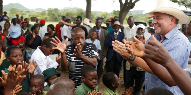 Commercial farmer Darryn Smart is welcomed at Lesbury Estates by village elders and children at a farm in Headlands communal lands east of the capital Harare, Zimbabwe, December 21, 2017.