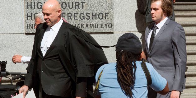 Henri van Breda (R) and his lawyer Pieter Botha (L) exit from the Western Cape High Court, after the start of his trial for allegedly killing his parents.