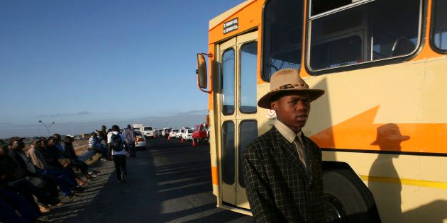 Commuters wait for buses on the outskirts of Khayelitsha township near Cape Town.