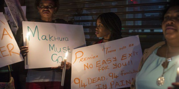 Demonstrators gathered in front of the office of the presidency of Gauteng State hold placards during a protest held over the death of 94 psychiatry patients sent to civil society organization headquarters by the Esidimeni Clinic in Johannesburg.