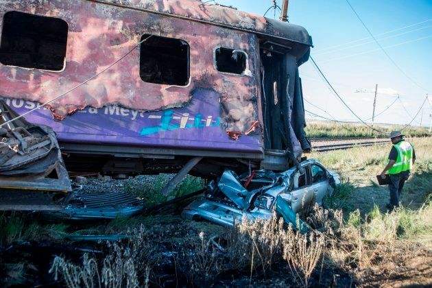 A Passenger Rail Agency South Africa (PRASA) inspector looks at the wreckage of a car which was being transported in a train after an accident near Kroonstad in the Free State Province.