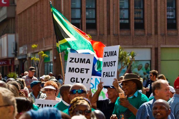 Protestors hold up placards reading 'Zuma must fall' during a demonstration of supporters of the Save South Africa (SaveSA) campaign, civil society organisations and political parties demanding South African President Jacob Zuma to resign on April 4, 2017 in Port Elizabeth, South Africa. South Africa's powerful trade union federation Cosatu, a key coalition partner of the ruling ANC, on Tuesday called for embattled President Jacob Zuma to resign following a deeply unpopular cabinet reshuffle. / AFP PHOTO / MICHAEL SHEEHAN (Photo credit should read MICHAEL SHEEHAN/AFP/Getty Images)