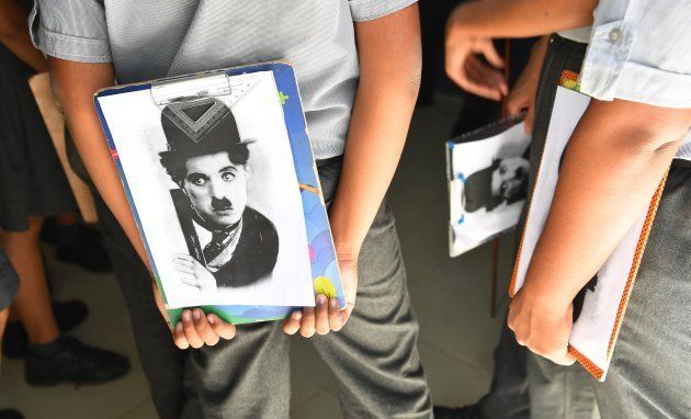 In this photograph taken on April 16, 2018, students stand together after a drawing competition organised by the Charlie Circle fan club on the occasion of the 129th birthday of the legendary actor Charlie Chaplin in Adipur (Photo credit: INDRANIL MUKHERJEE/AFP/Getty Images)