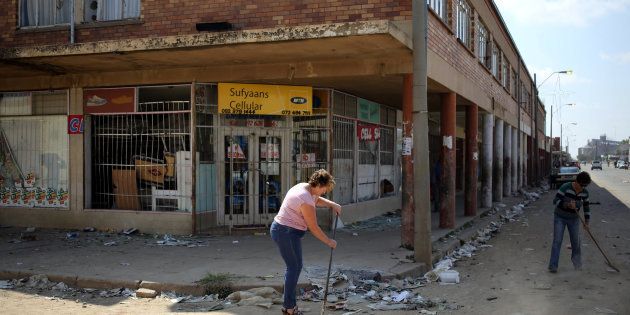 Locals clean up after over-night looting, when protesters took to the streets to demonstrate the killing of a boy in Coligny.