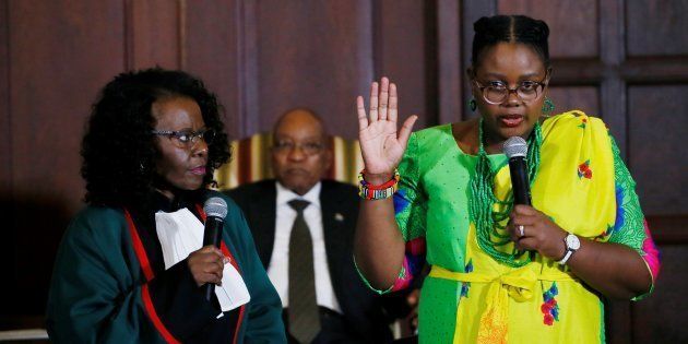 South African president Jacob Zuma (back) looks on as Constitutional Court judge Sisi Khampepe (L) administers the swearing-in of the newly appointed Minister of Energy Mmamoloko Kubayi (R) during a ceremony at Presidential Guest House on March 31, 2017 in Pretoria. South African President Jacob Zuma's sweeping cabinet overhaul exposes deep divisions between the ANC's apartheid-struggle old guard and a new generation often accused of not living up to expectations. / AFP PHOTO / Phill MAGAKOE (Photo credit should read PHILL MAGAKOE/AFP/Getty Images)