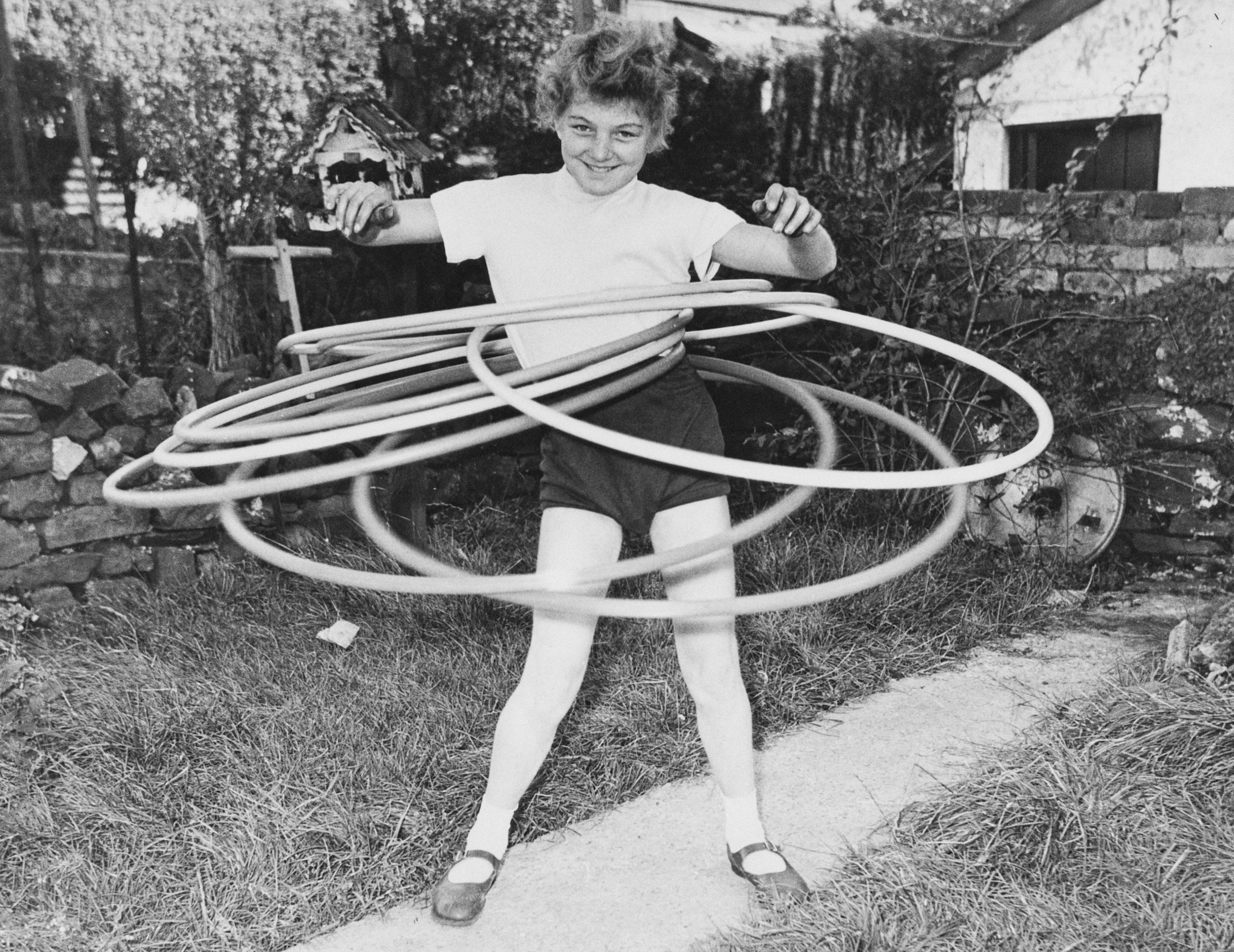 11-year-old Ann Evans of Aberdare, Wales, the world toy hoop marathon champion, keeps seven hoops twirling simultaneously, No