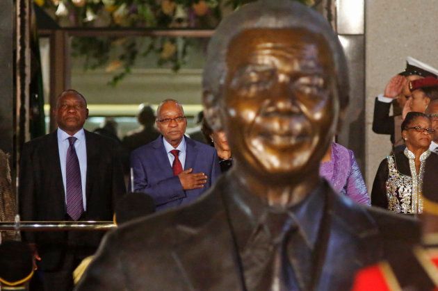 South African President Jacob Zuma (2nd L) stands behind a statue of former South African President Nelson Mandela. On Zuma's left is South African Deputy President Cyril Ramaphosa. REUTERS/Schalk van Zuydam/Pool (SOUTH AFRICA - Tags: POLITICS)