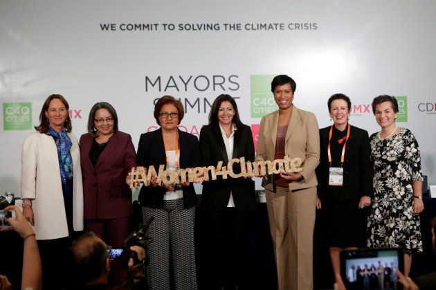 Paris mayor Anne Hidalgo poses with Caracas mayor Helen Fernandez, Cape Town mayor Patricia de Lille, French environment minister Segolene Royal, Washington mayor Muriel Bowser, Sydney lord mayor Clover Moore and Christiana Figueres, former executive secretary of United Nations Framework Convention on Climate Change, pose with a placard after a news conference at the C40 Mayors Summit at a hotel in Mexico City, Mexico. December 2, 2016.