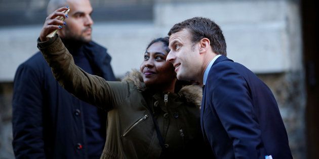 Emmanuel Macron poses for a selfie as he leaves his home in Paris.
