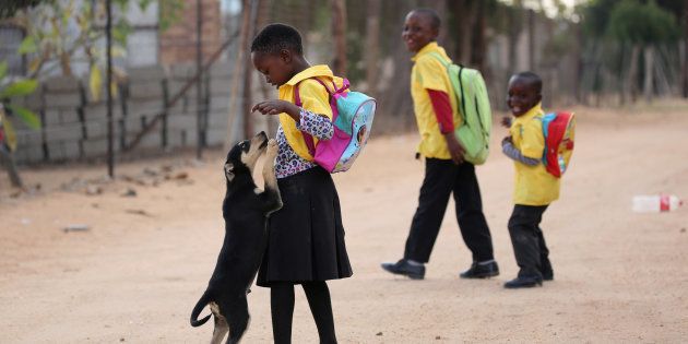 A school girl is welcomed by a puppy as she returns from school at Mapela village near the Mogalakwena platinum mine in Mokopane , north-western part of South Africa , Limpopo province. May 18, 2016. REUTERS/Siphiwe Sibeko