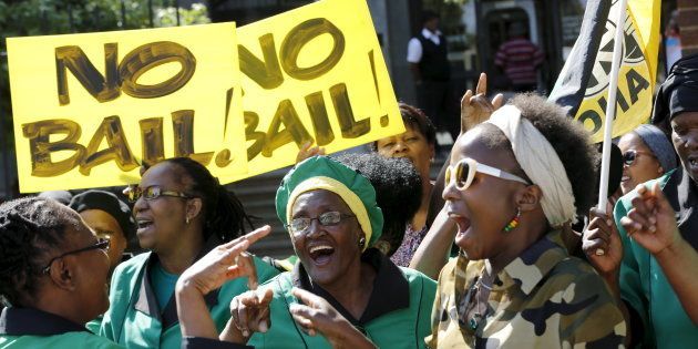 Members of the ANC Women's League chant slogans as they hold placards after a bail hearing of Danish man Peter Frederiksen was postponed at the Bloemfontein court September 28, 2015. The Danish gun store owner found with 21 pieces of female genitals stored in his home freezer has been detained and will face charges of sexual assault, intimidation and domestic violence, South African police said last Monday.