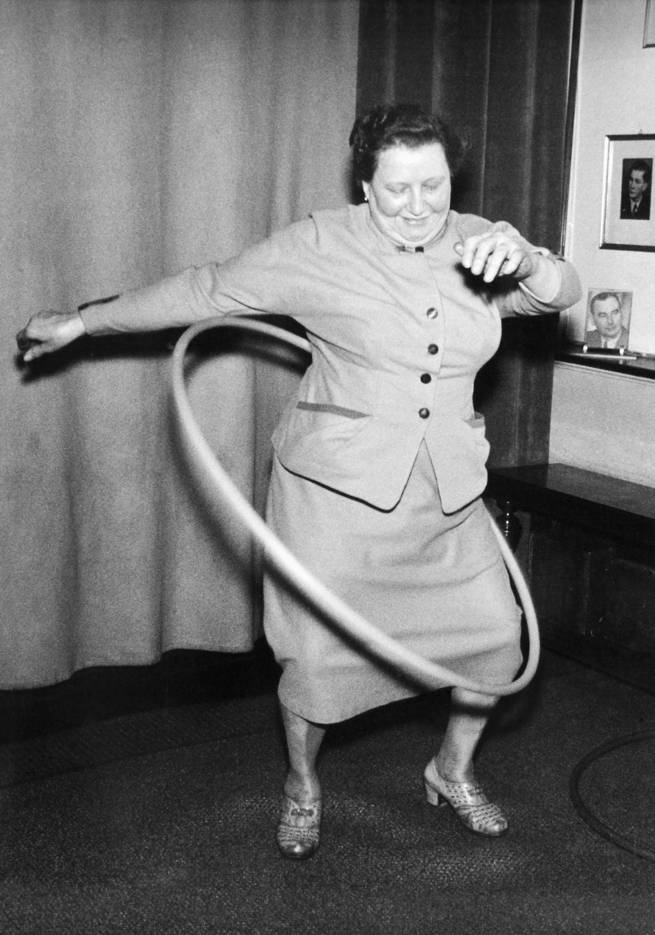 A European woman tries out a toy hoop, circa 1958.