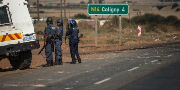 A South African riot police officers patrol the streets following violent protest on May 9, 2017 in Coligny, South Africa.
