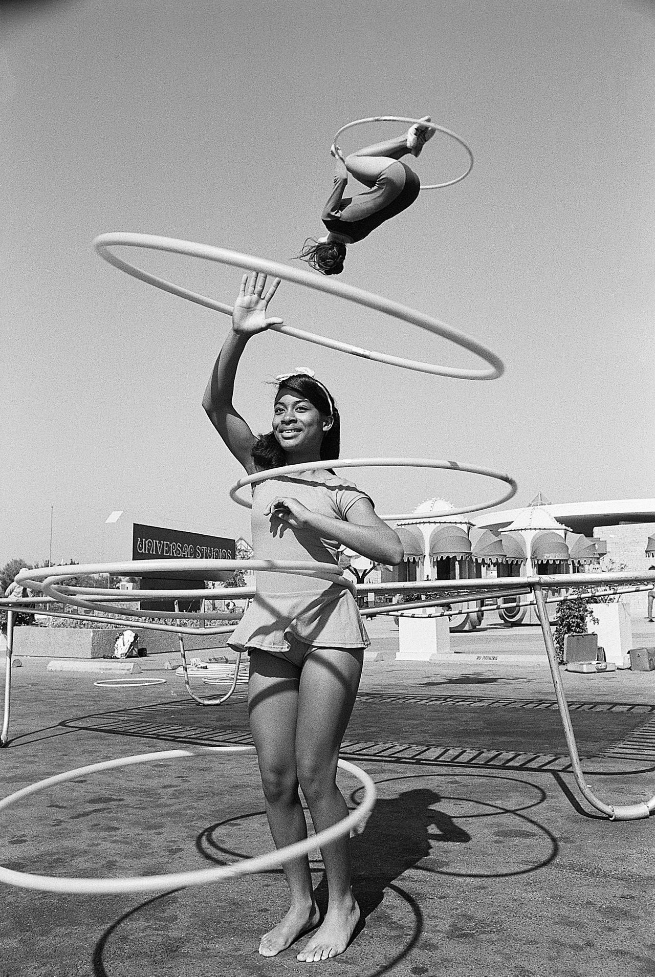 National hula hoop champion Sandra Gaylord spins her hoops in 1972, as world professional trampoline champion Judy Johnson does her thing using a hoop as well.