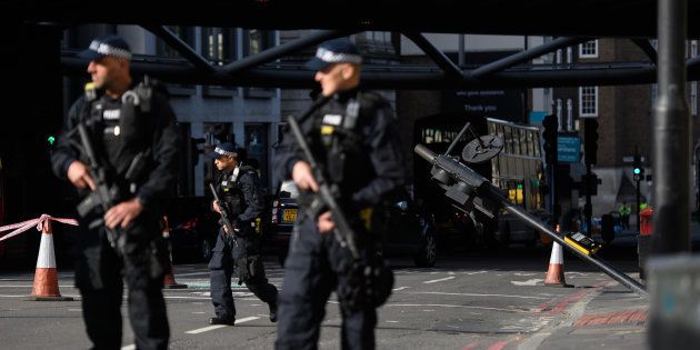 Armed police officers stand near the location where the attackers' van crashed, after London Bridge was reopened on June 5 following the June 3 terror attack in London, England.