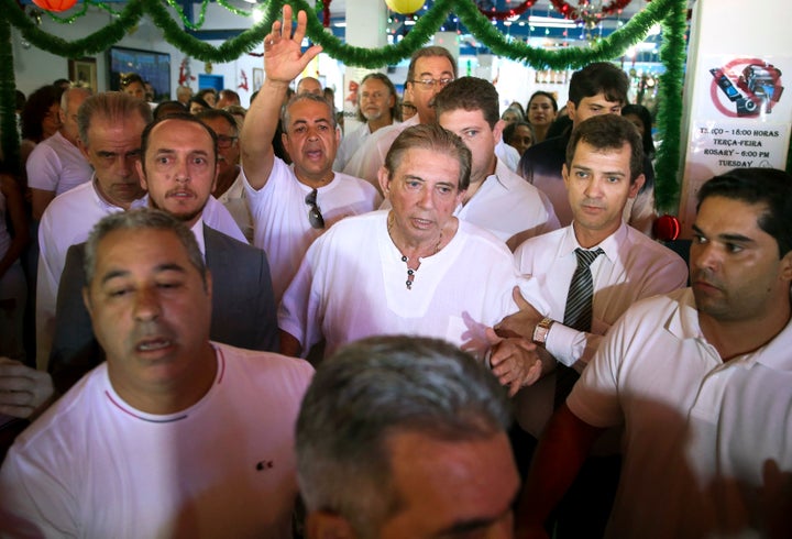 João Teixeira de Faria (center), better known as John of God, arrives at the Dom Inacio Loyola House in Abadiânia, Brazil, on Dec. 12, 2018. Earlier that month, several of his alleged victims appeared on a popular Brazilian television show to speak of the abuse.