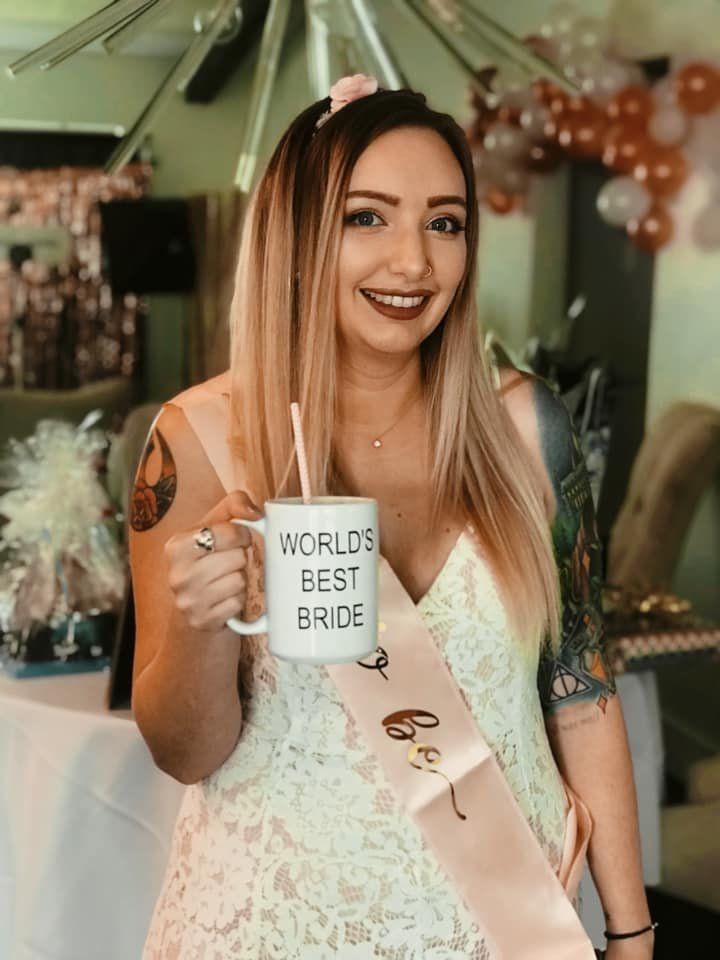 Brown holds a "World's Best Bride" mug, another nod to "The Office."