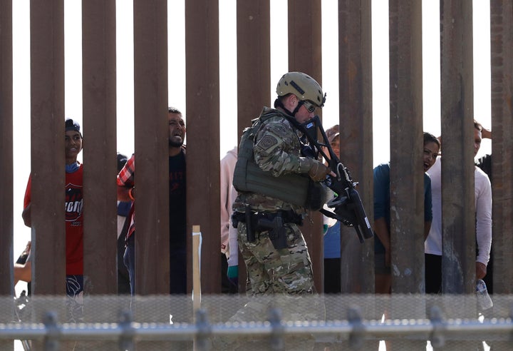 U.S. Customs and Border Protection officers walks along a wall at the border between Mexico and the United States, as seen fr