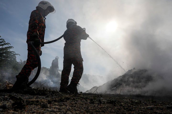 Firefighters put out a blaze at an illegal dumpsite on a palm oil plantation near Jenjarom, Malaysia, Feb. 2. Plastic fires are notoriously difficult to extinguish and release toxins into the air. People in Jenjarom knew that unauthorized plastic trash fires were burning somewhere near their homes because they could smell the chemicals in the air.