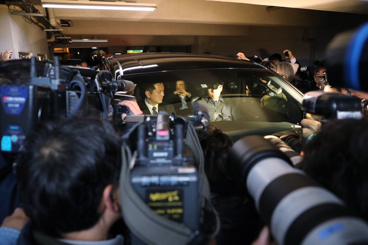 弁護士事務所の前でゴーンの乗った車を取り囲む報道陣