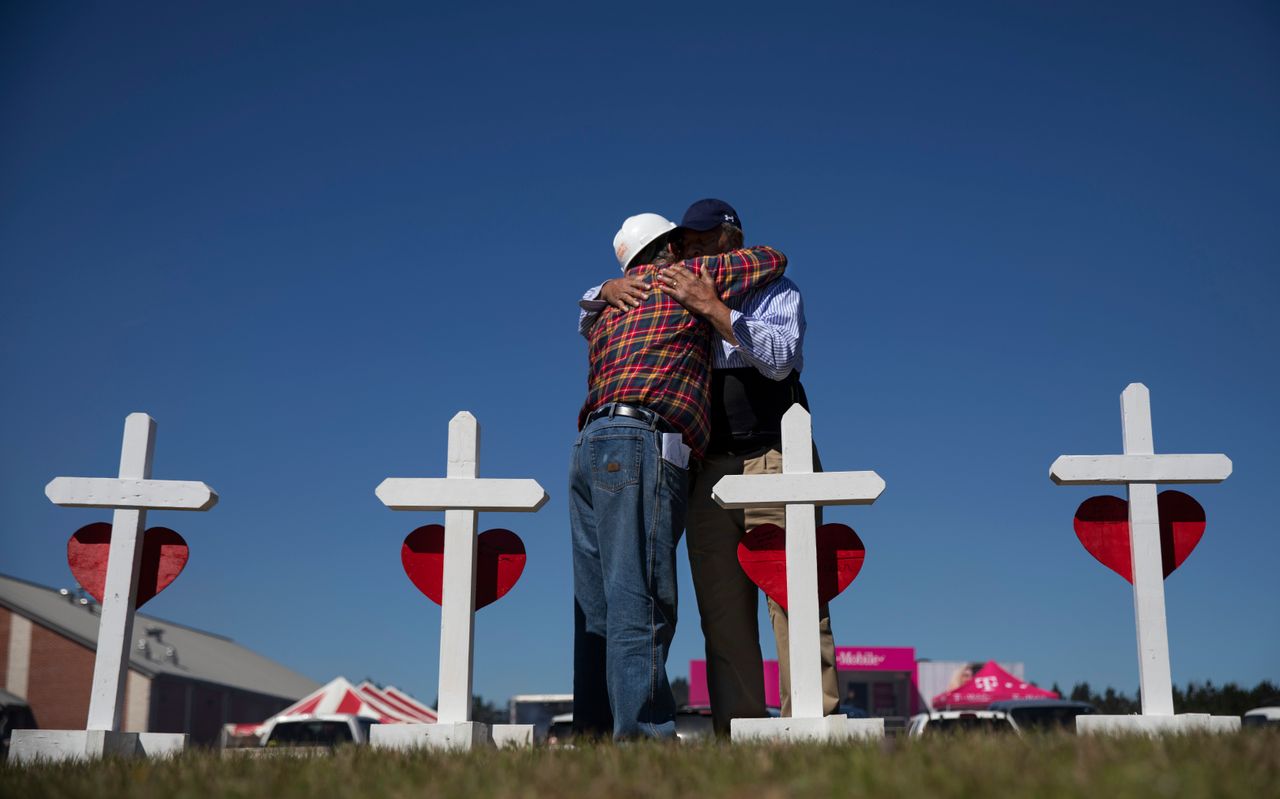Rev. Arthur Thomas, right, of Mt. Nebo Baptist Church, is embraced by Greg Zanis, who built a cross for each victim of the tornado and placed them as a makeshift memorial in Beauregard, Alabama, March 6, 2019. Thomas said several of the dead were members of his congregation.