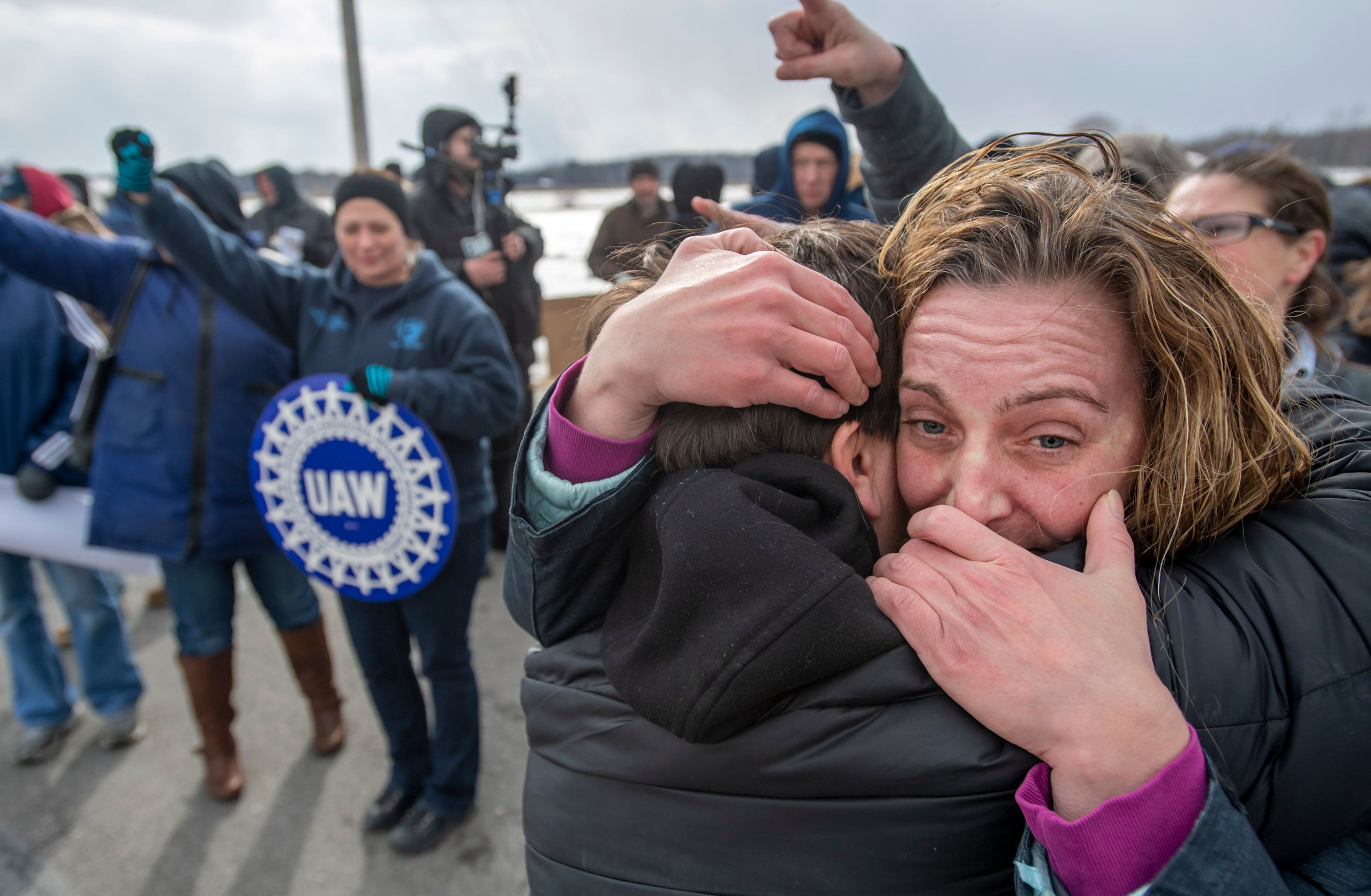 Amy Drennen, right, of Lordstown, Ohio, an employee at General Motors for 12 years, receives a hug from Pam Clark, as people