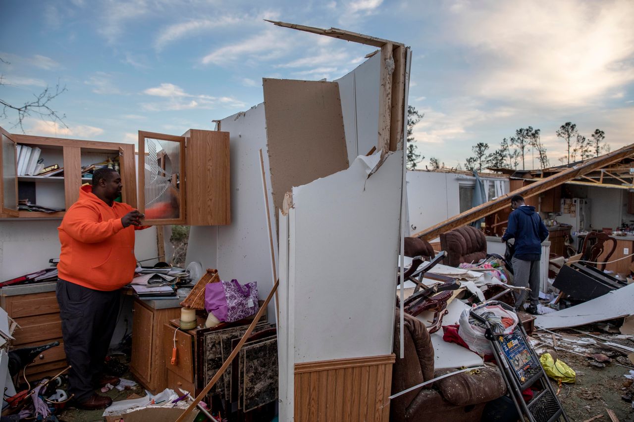 Granadas Baker, left, and son Granadas Jr. 18, right, retrieve personal items from the damaged home where they survived a tornado a day earlier in Beauregard, Alabama, Monday, March 4, 2019.